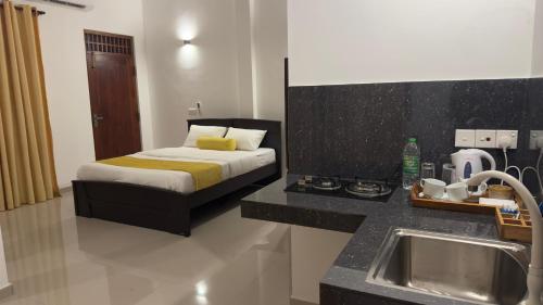 a bedroom with a bed and a sink in it at Clement's Homestay in Kandana