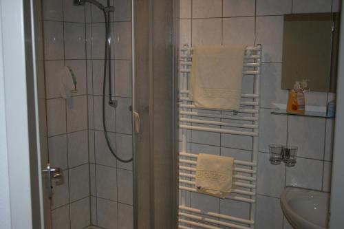 a bathroom with a shower and a sink and towels at Landgasthaus Hotel Wolters in Kerken