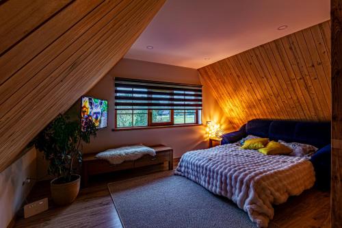 a bedroom with a bed and a window at Mīļpirtiņa Guguči in Straupe