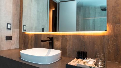 a bathroom with a white sink and a mirror at EHBoutique Experience in El Calafate