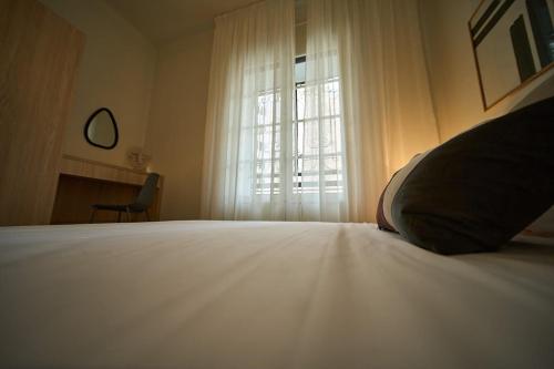 a bedroom with a white bed with a window at Le Jardin Privé in Alger