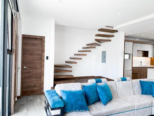 a living room with a couch and a staircase at Lujosa y exclusiva casa en Salinas! Cerca de todo in Salinas