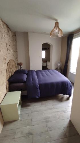 - une chambre avec un lit et une couverture violette dans l'établissement Appartement cosy avec terrasse, à Sainte-Foy-la-Grande