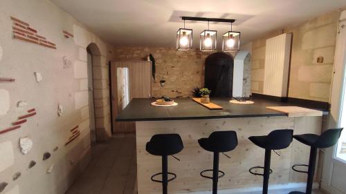 a kitchen with stools at a counter in a room at Appartement cosy avec terrasse in Sainte-Foy-la-Grande
