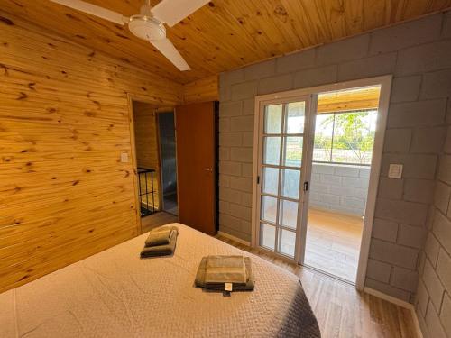 una camera da letto con un letto in una stanza con pareti in legno di El Rejunte a Paso del Rey