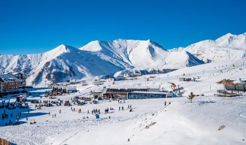 a group of people on a ski slope in the snow at New Gudauri Neo Apartments in Gudauri