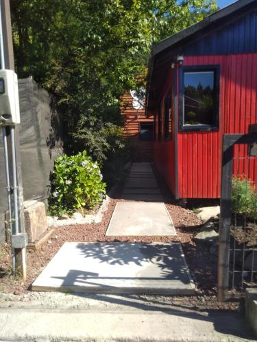 a path leading to a red shed with a red door at Cabañas El_Nativo2 in Choshuenco