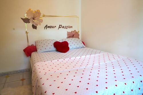 a bedroom with a bed with red hearts on it at Le Paradis de Zette in La Trinité