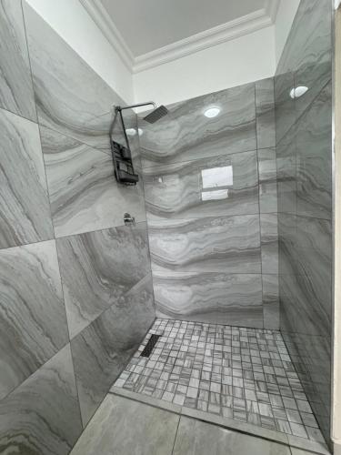 a bathroom with a large shower with marble tiles at CalmeQuies Home in Pretoria