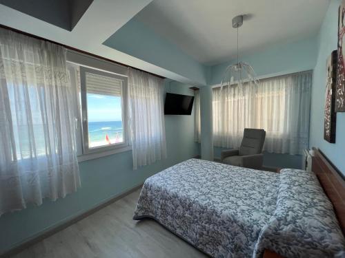 a bedroom with a bed and a view of the ocean at Marusía apartamento in Malpica