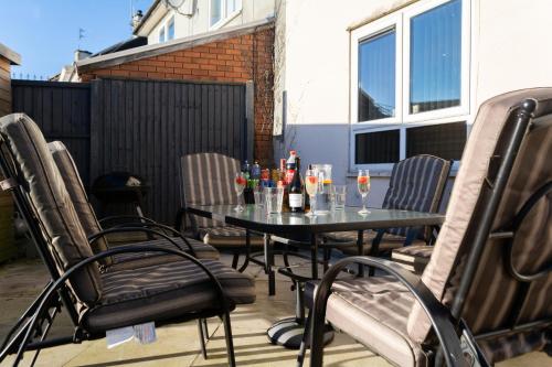 a table and chairs on a patio with drinks on it at 3 Bedrooms homely House sleeps seven comfortably with three double beds and one single bed Free parking on private drive for upto 3 cars vans For business travellers contractors and holiday goers Near all major transport links in Leicester
