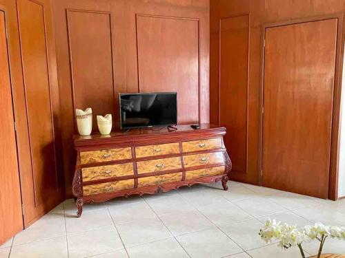 a television sitting on top of a wooden dresser at Excelente Villa con alberca in Ajijic