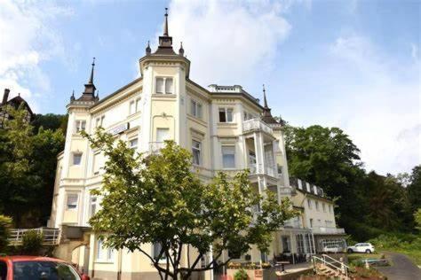 a large white building with a tree in front of it at Trip Inn Parkhotel Bad Ems in Bad Ems