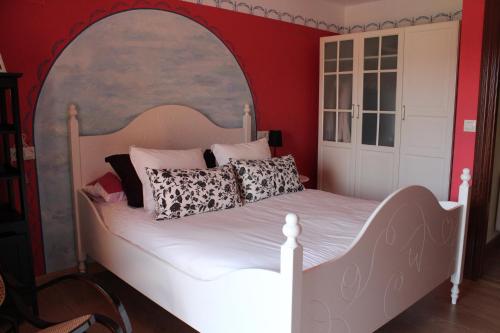 a bedroom with a white bed in a red wall at Casa El Acebo in Muros de Nalón