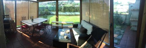 a balcony with a couch and a table and a table at Casa El Acebo in Muros de Nalón