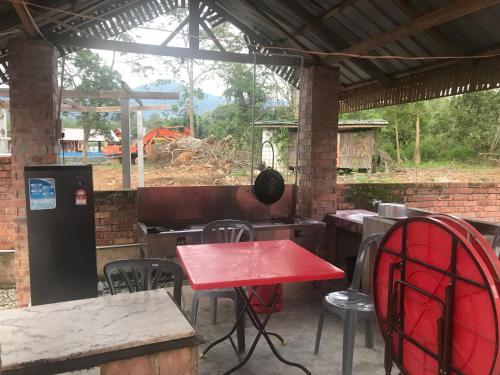 a patio with a red table and chairs and a grill at Ztg janda baik retreat in Bentong
