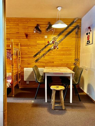 une chambre avec une table et quelques skis sur le mur dans l'établissement Slopeside La Plagne Bellecote, à La Plagne Tarentaise