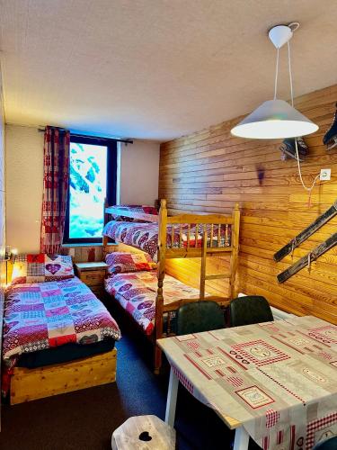 Cette chambre comprend 2 lits, une table et une télévision. dans l'établissement Slopeside La Plagne Bellecote, à La Plagne Tarentaise