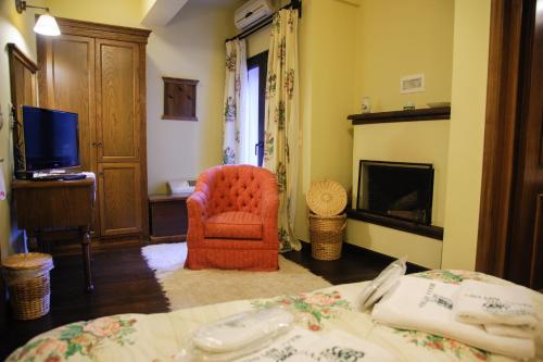a bedroom with a bed and a chair and a television at Villa Virginia Hotel in Karpenision