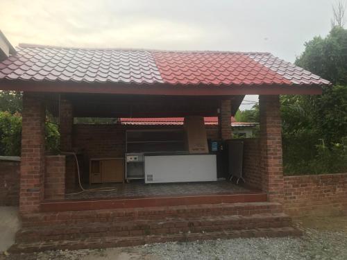 a brick pavilion with a red roof at Ztg janda baik retreat in Bentong