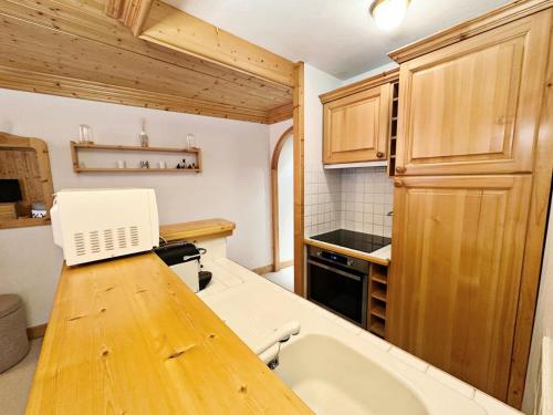 une cuisine avec un comptoir en bois et un évier dans l'établissement Résidence Lachat - Bel appartement 3 pièces 5 personnes proche de Méribel centre MAE-0321, à Les Allues