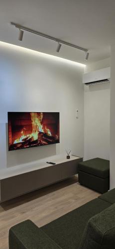 a living room with a fireplace on the wall at Tris Apartments Tirana in Tirana