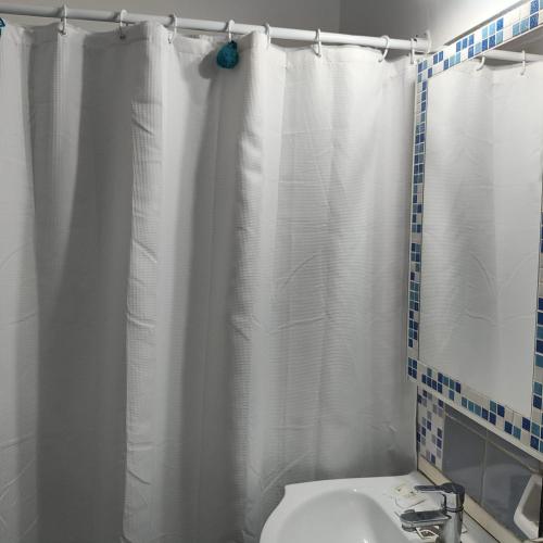 Estilo Mar في مار ديل بلاتا: حمام مع ستارة دش بيضاء ومغسلة