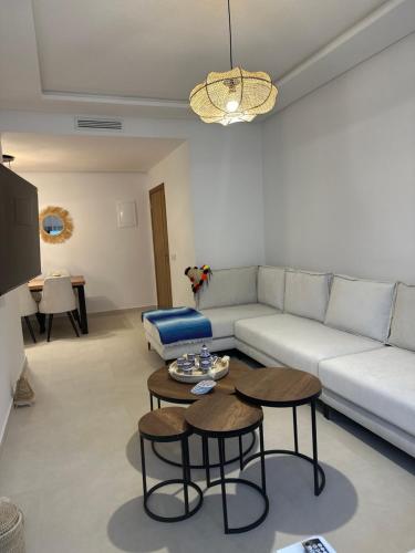 a living room with a couch and two tables at Amina in Marina Smir