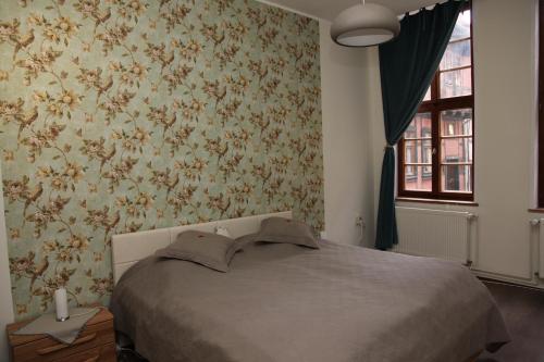 a bedroom with a bed and floral wallpaper at Ferienwohnung Höllenblick in Quedlinburg