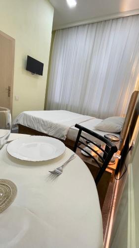 a room with two beds and a table with a fork on it at RUNO inn Hotel in Baku