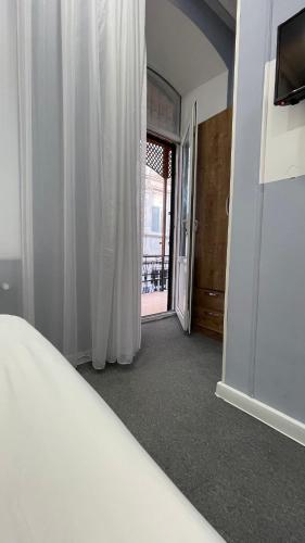 a bedroom with a bed and a door to a balcony at RUNO inn Hotel in Baku