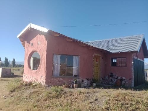 a red house with a yellow door in a field at Barro tal vez in Trevelin