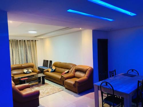 a living room with brown leather furniture and a blue light at sonu guest house in Dakar