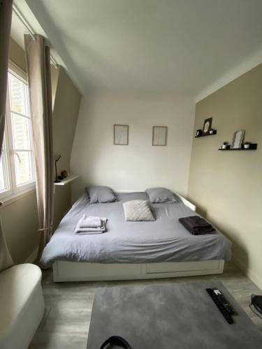 une chambre avec un lit blanc et un canapé dans l'établissement Appartement vue tour Eiffel ligne 14 à côté de Paris, à Gentilly