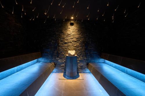 a room with blue lights and a stone wall at Hotel Cesa Tyrol in Canazei