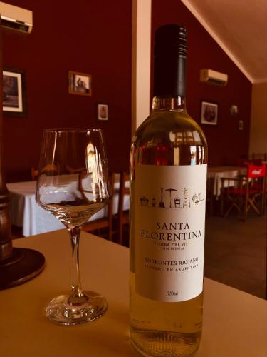 a bottle of wine sitting next to a glass at Hotel Valle Colorado in Villa Unión