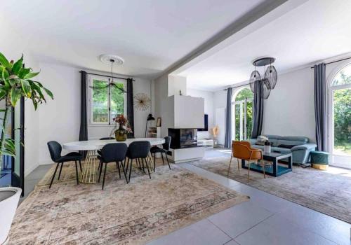 une salle à manger et un salon avec une table et des chaises dans l'établissement Serenity House - Maison 6 personnes - Villennes-sur-Seine, à Villennes-sur-Seine