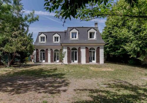 une grande maison avec une grande cour dans l'établissement Serenity House - Maison 6 personnes - Villennes-sur-Seine, à Villennes-sur-Seine