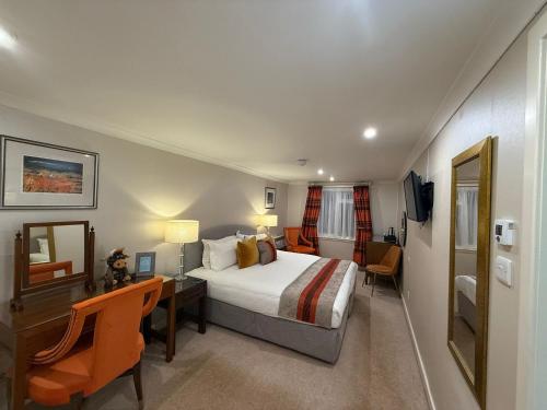 a hotel room with a bed and a desk and a desk at The Airds Hotel and Restaurant in Port Appin