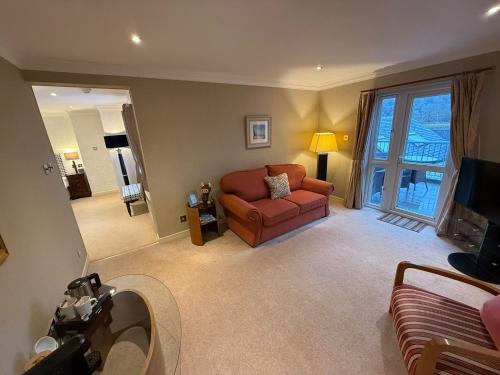 a living room with a couch and a television at The Airds Hotel and Restaurant in Port Appin