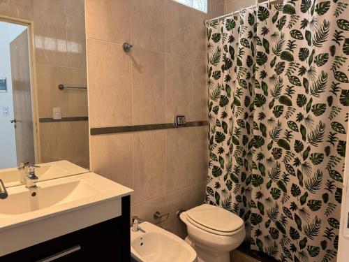 Un baño con lavabo, inodoro y cortina de ducha. en Apartment with Patio, Gym and Pool, en Buenos Aires