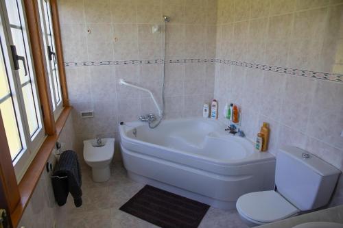 a bathroom with a white tub and a toilet at Beachfront Surf & Holiday House, Charming & Quiet in Villarrube