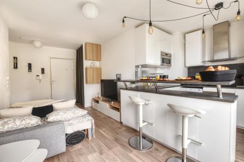 a kitchen and living room with a couch and a counter at Le Cosy De l'Ourcq T2 40m2 20 min de Paris in Villepinte