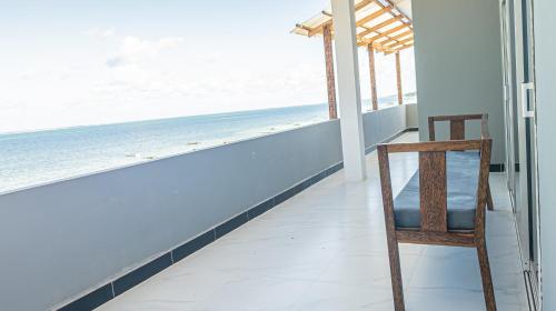 a chair in a room with a view of the ocean at Spacious Beachfront Condo -AC - WIFI, Uroa Escape Zanzibar in Uroa