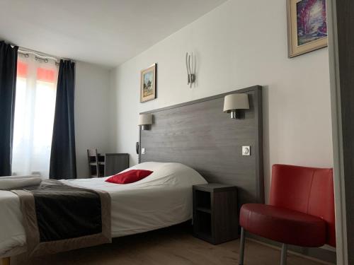 une chambre avec un lit et une chaise rouge dans l'établissement Hôtel Résidence Châtillon, à Paris