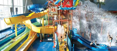 a water slide in a water park with people on it at Niagara Creekside B&B - Waterfront suite in Niagara Falls