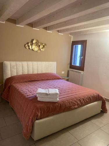 une chambre avec un lit avec deux serviettes dessus dans l'établissement Elena's Home piano terzo, à Chioggia