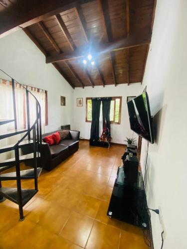a living room with a couch and a tv at Casa de verano in Mar del Plata