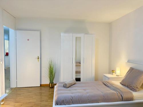 a white bedroom with a bed and a mirror at Skyline Retreat Jedes Zimmer mit TV in Baden