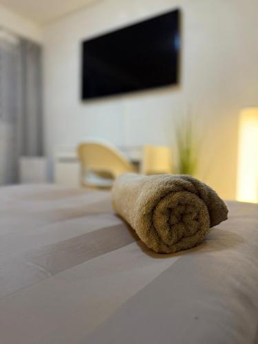 a rolled up towel sitting on top of a bed at Skyline Retreat Jedes Zimmer mit TV in Baden